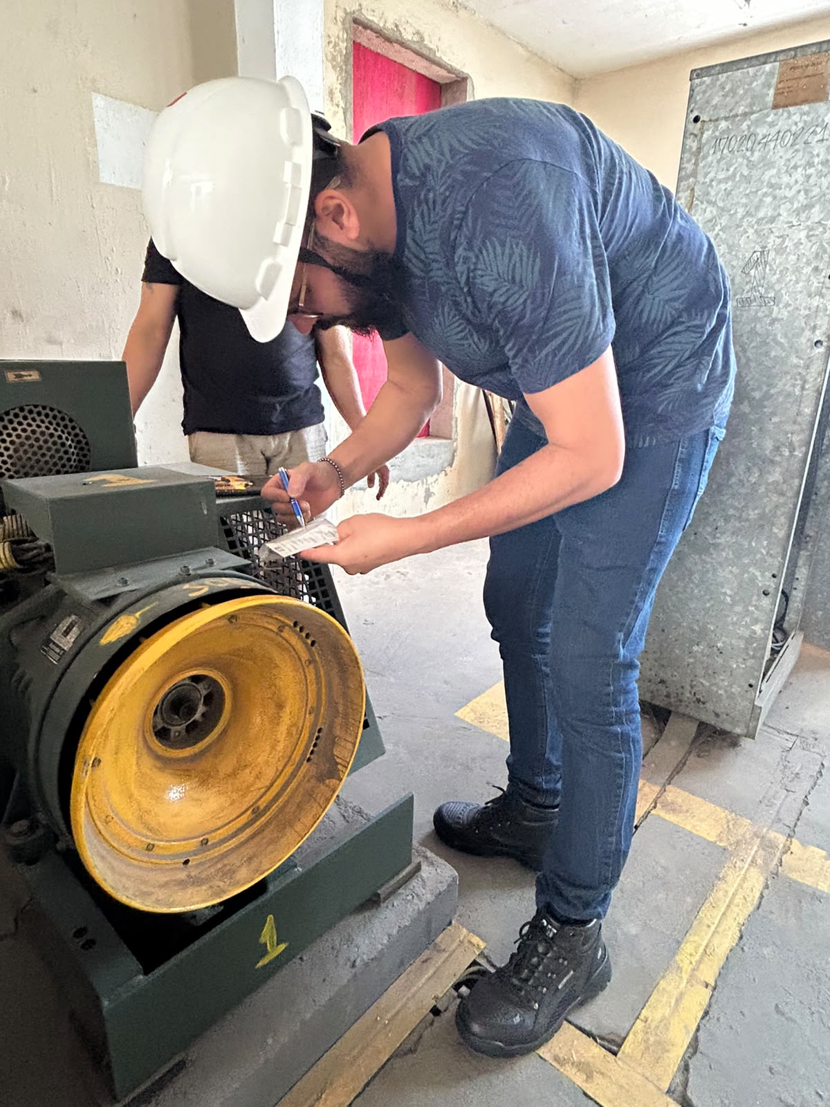 Registro técnico em campo, preenchimento de etiqueta junto ao motor industrial