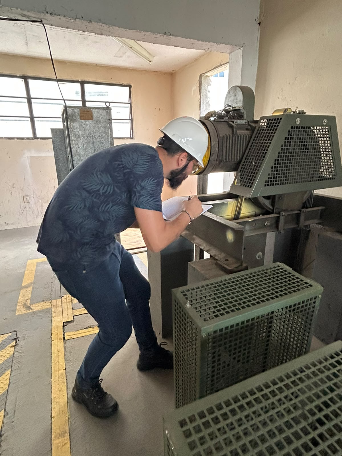 Inspeção técnica de motor industrial com anotação em prancheta